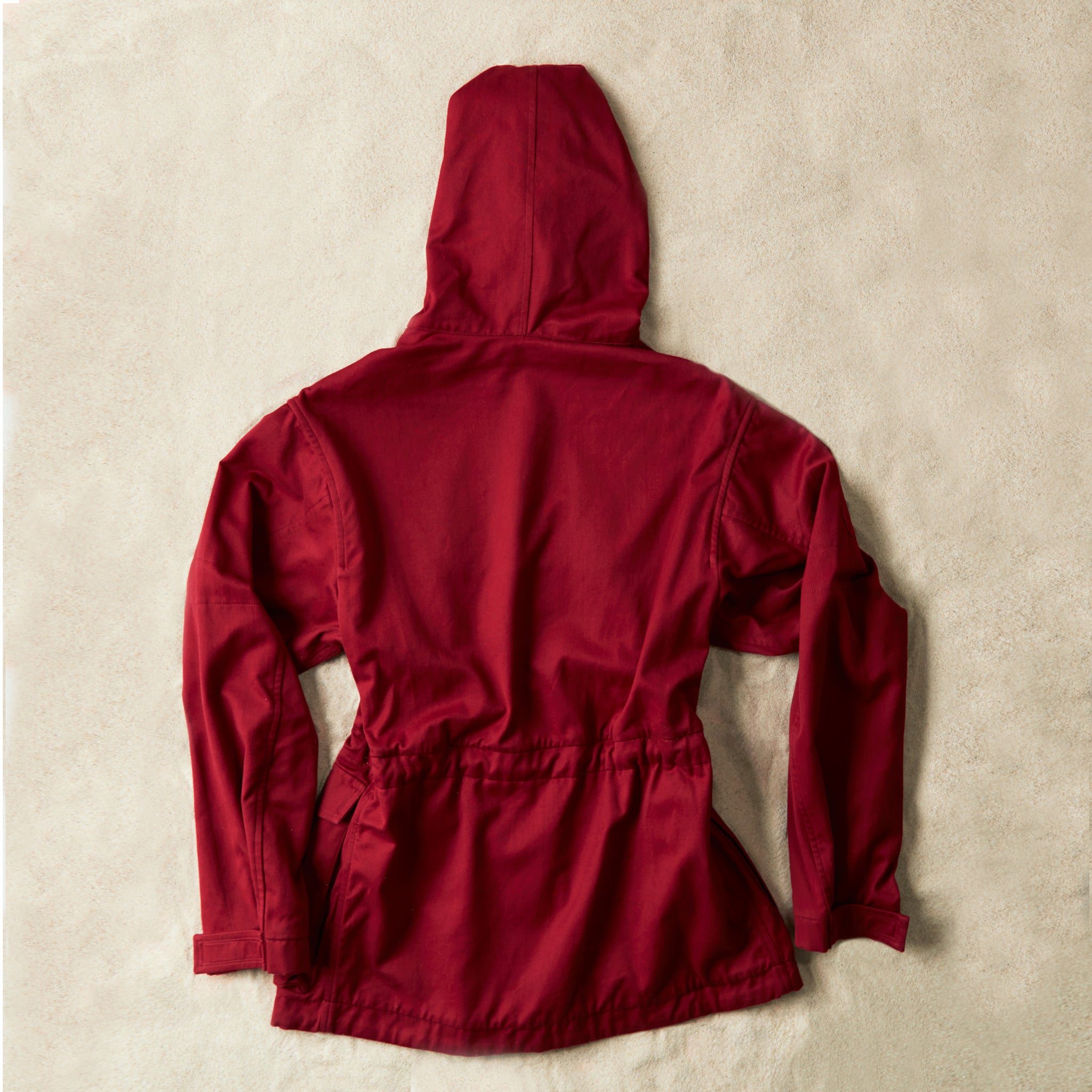 Red ranger safari jacket back view against a sand background