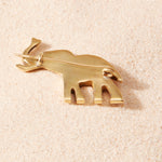 Back of brass elephant pin on a sand background