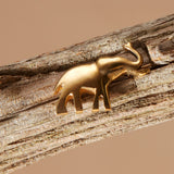 Brass elephant pin on a wooden branch