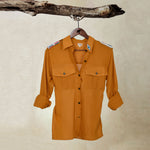 Amber Yellow Orange Lightweight Ranger Shirt with White and Colorful Beaded Epaulettes on a hanger from a branch