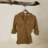 Brown Lightweight Ranger Shirt with White and Colorful Beaded Epaulettes on a hanger from a branch