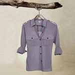 Grey Lightweight Ranger Shirt with White and Colorful Beaded Epaulettes on a hanger from a branch