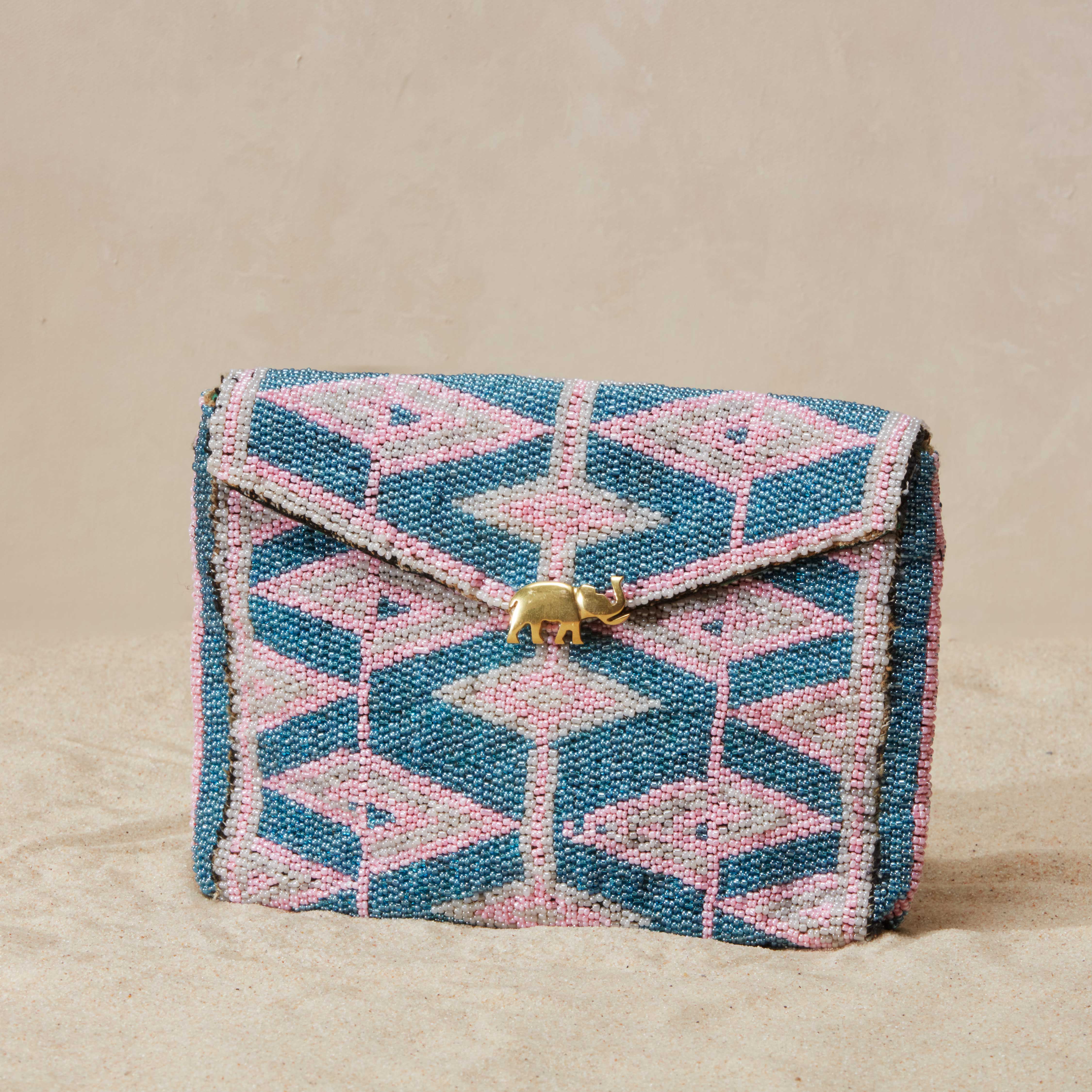 Beaded clutch bag with geometric pattern on a beige background