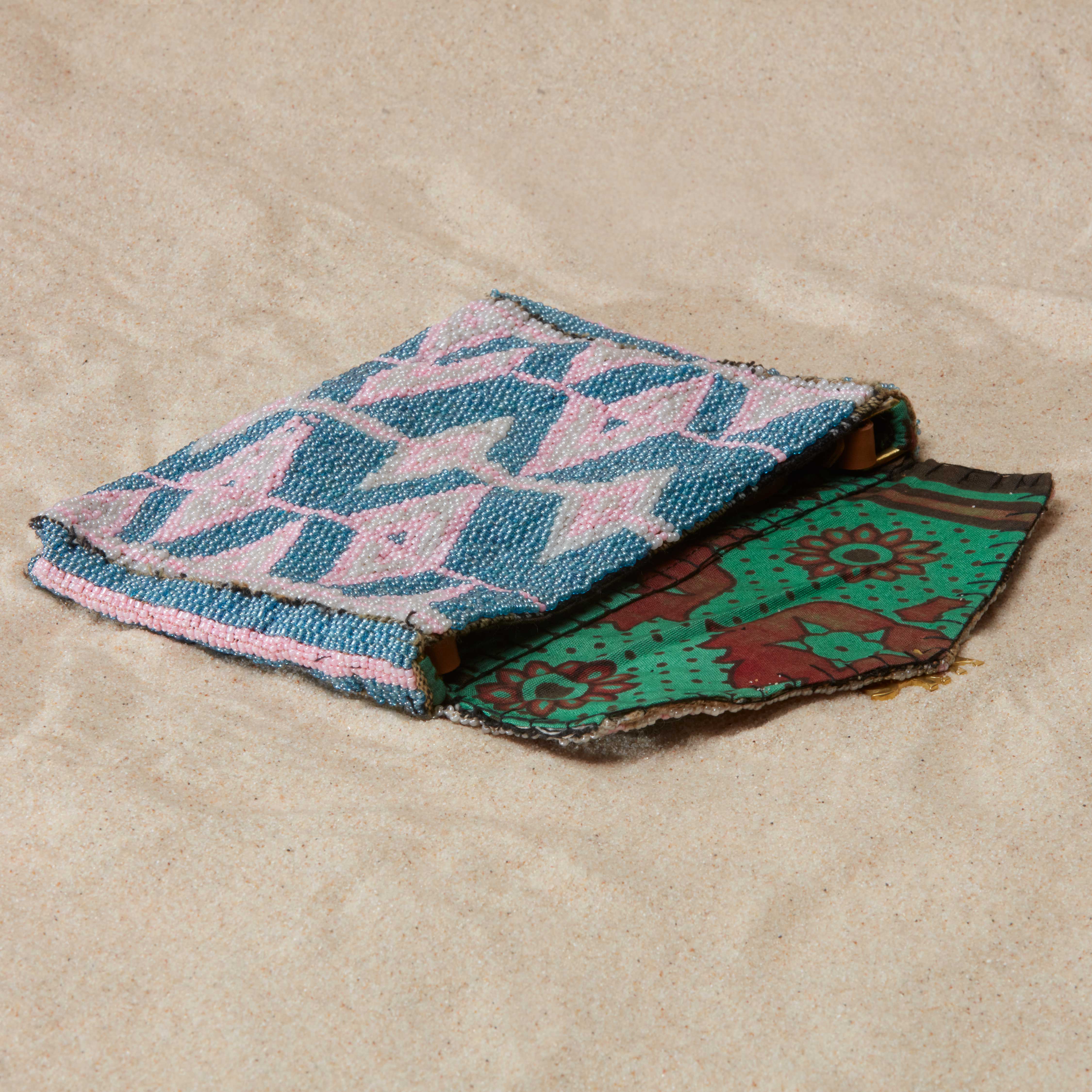 Beaded geometric pattern clutch with a green colorful kanga fabric lining