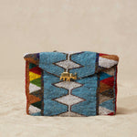 Handcrafted woven beaded pouch with geometric pattern and gold elephant on beige background