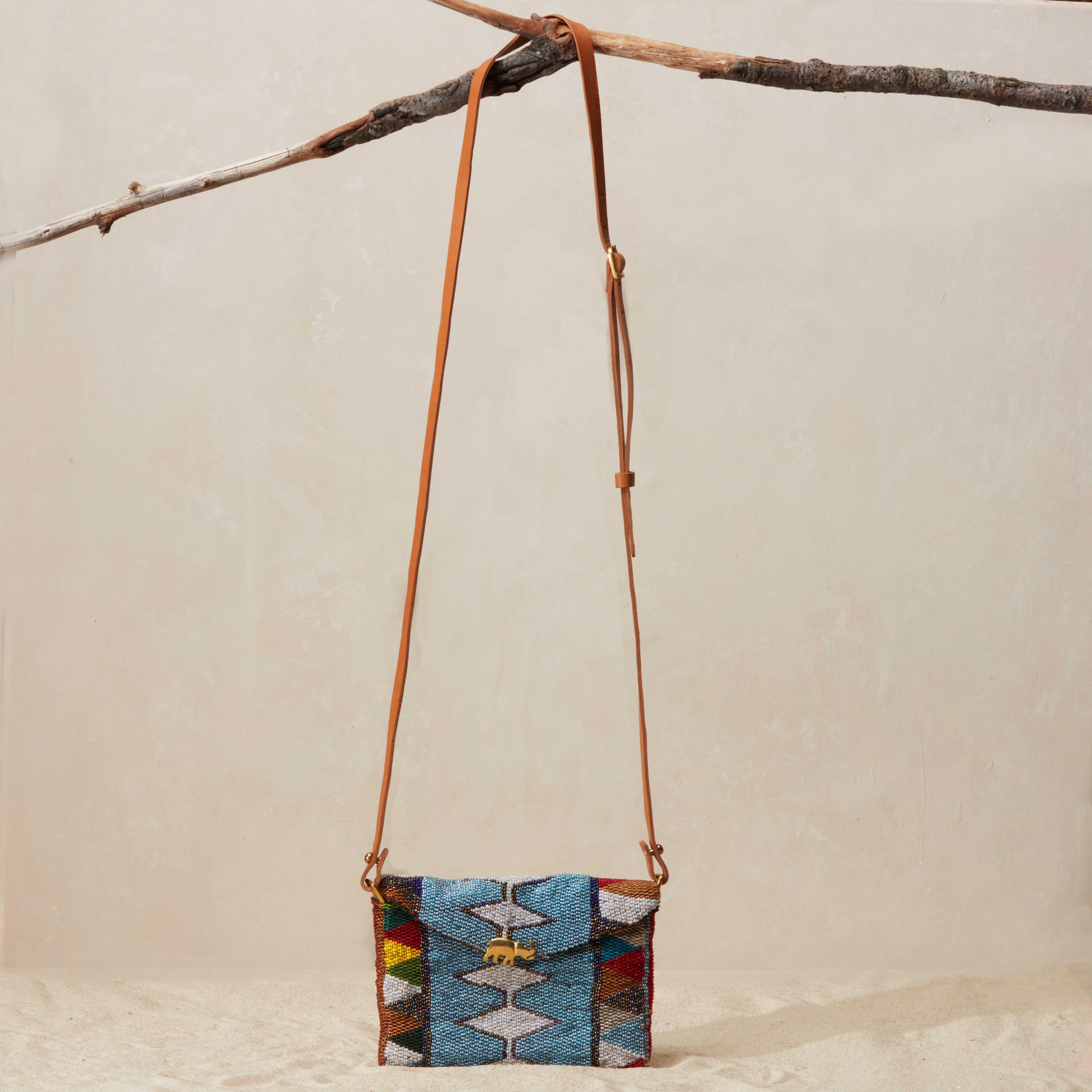 Small beaded handbag with a colorful pattern hanging on a branch