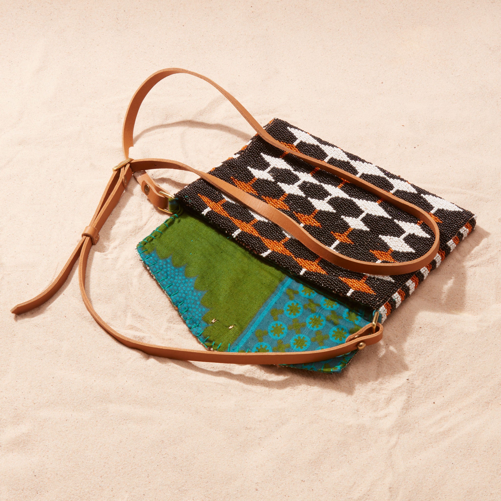 Handbag with geometric pattern showing green and blue kanga fabric lining