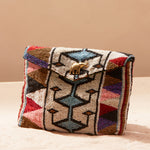 Multicolored beaded handbag with geometric pattern on a sand background