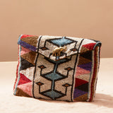 Multicolored beaded handbag with geometric pattern on a sand background