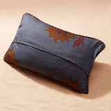Back view of pillow showing blue fabric with floral patterns on a beige background