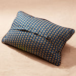 Back of pillow showing blue and beige polka dot fabric on a beige background