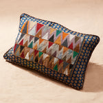 Decorative pillow with beaded geometric pattern on a sand background
