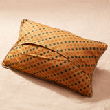 Back view of pillow showing yellow fabric with yellow and green polka dots against a sand background