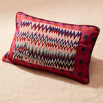 Colorful decorative pillow with beaded zigzag pattern on a beige background