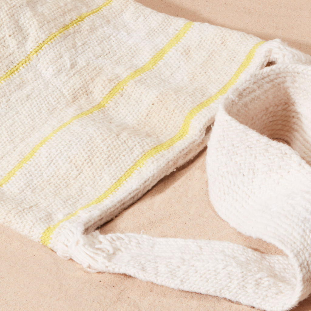 Close-up of a textured woven bag straps with thin yellow stripes