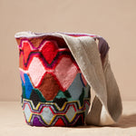 Colorful patterned woven bag on a beige background