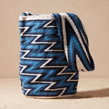 Blue and white zigzag patterned bag on a beige background