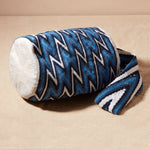 Bottom view of woven bag with blue and white zigzag pattern against a beige background