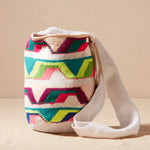 Colorful woven bag with geometric pattern on a beige background