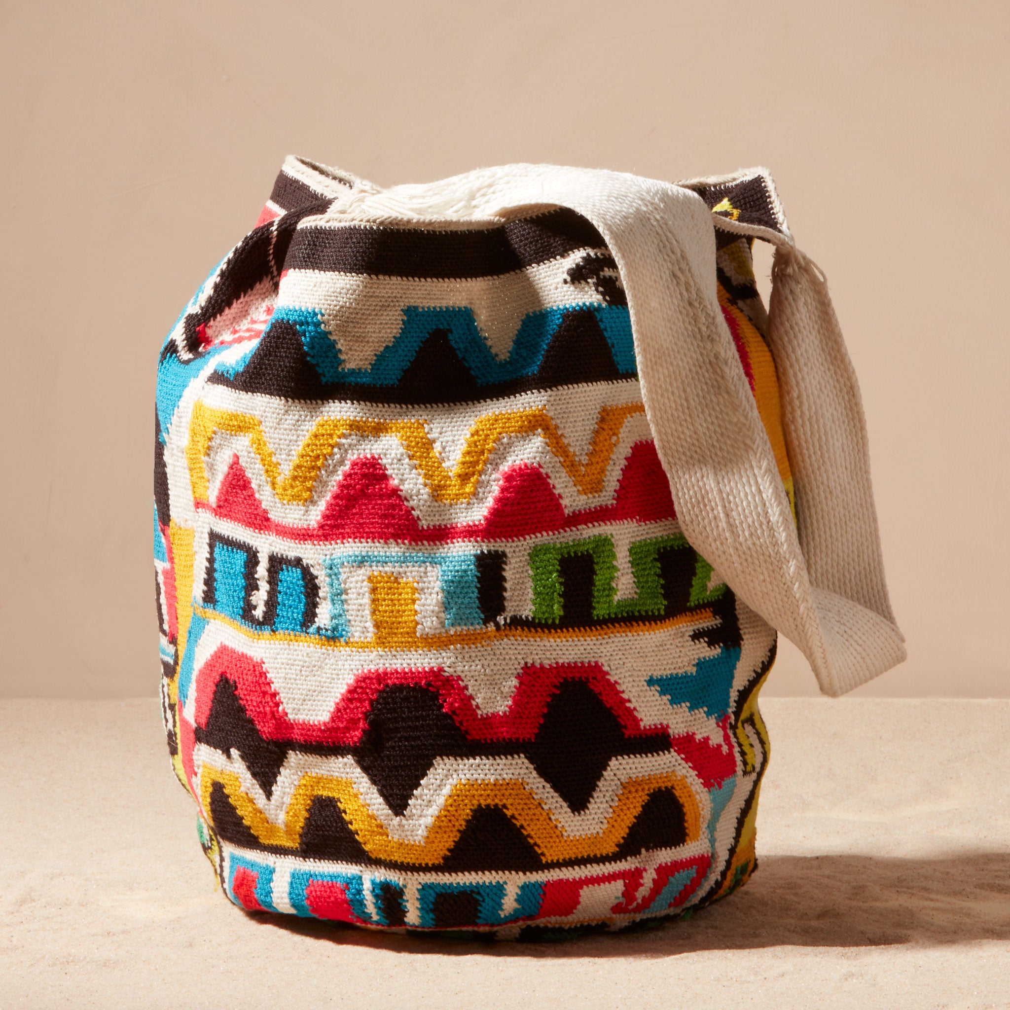 Colorful patterned bag with a strap on a beige background