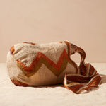 Side view of textured woven bag with a zigzag pattern against a beige background