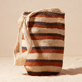 Woven bag with striped pattern on a beige background