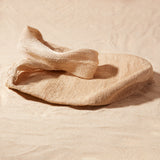 Flat view of beige woven bag on a sand surface