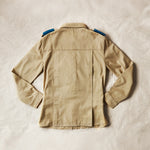 Flat back view of Khaki safari shirt  on a sand background