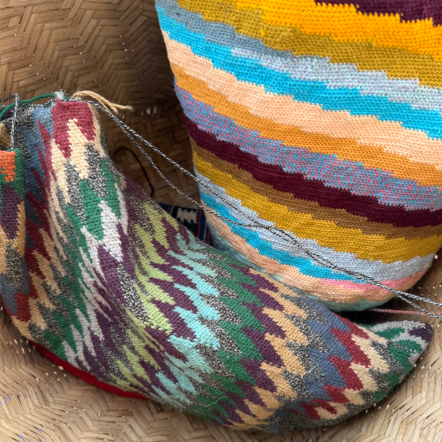 Colorful woven bags on a textured basket surface