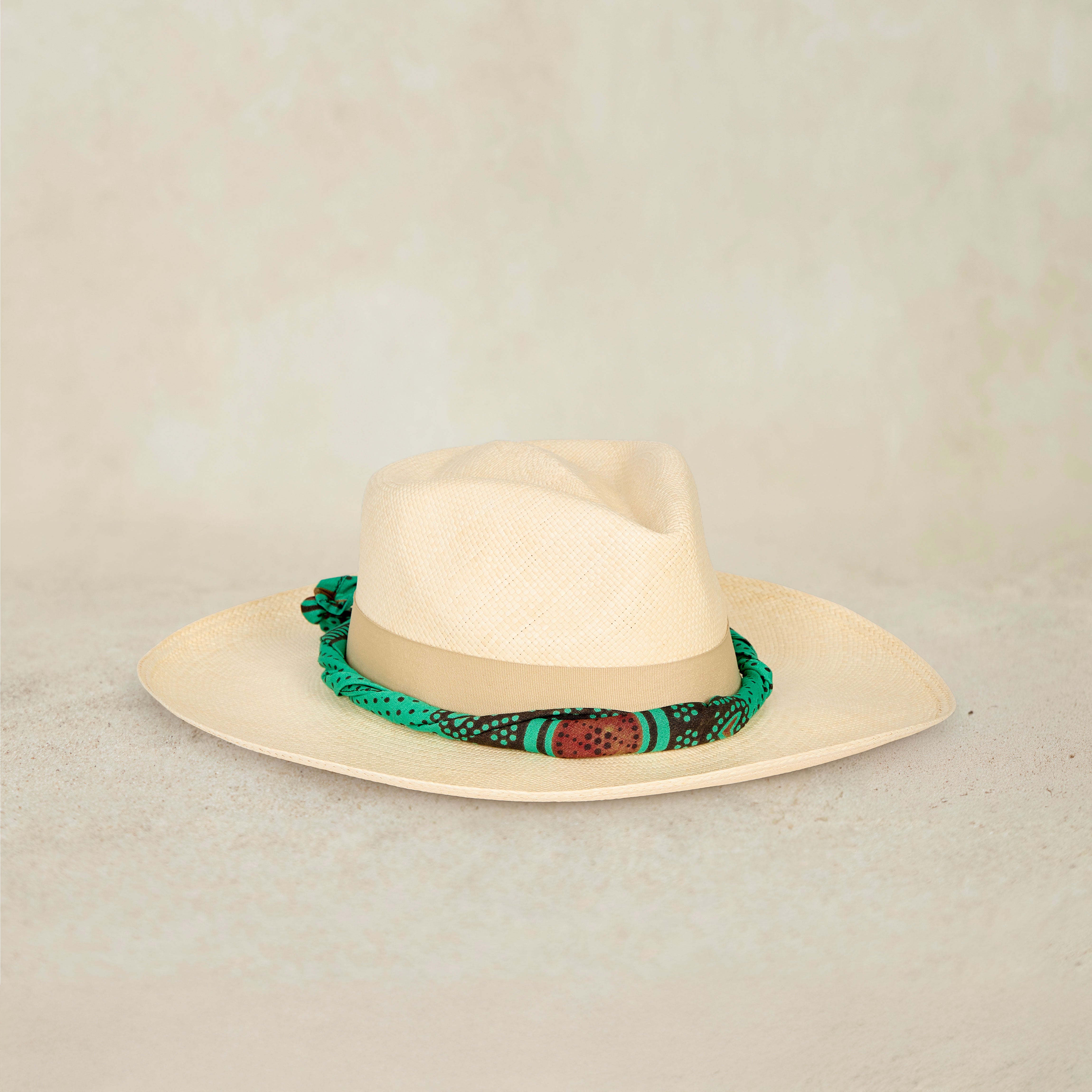 Natural Straw Hat with Wide Brim with Colorful Green Wrapped Band on Sand Background